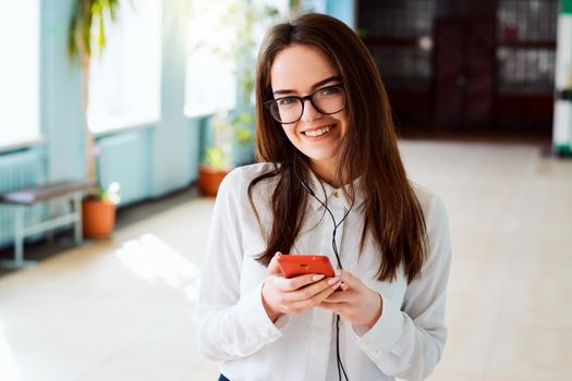 Learner listening to music in the corridor of conventional university after classes while going home