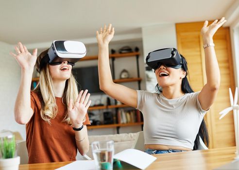 Two girls having fun with vr glasses virtual reality inovation at home or in office