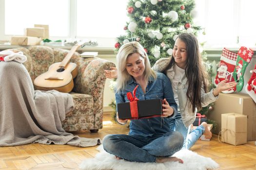 mother and daughter near the Christmas tree.