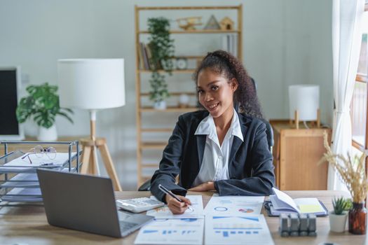 A portrait of an African Americans businesswoman showing a smile on her face as she works to increase the profits of her own business