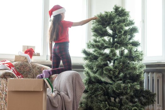 little girl makes an artificial Christmas tree