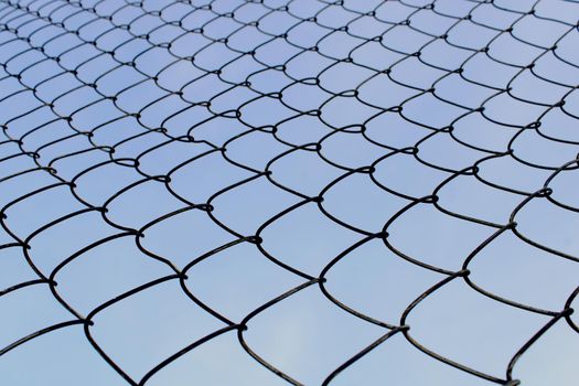 Metal mesh close-up against the blue sky. The concept of freedom and peace.