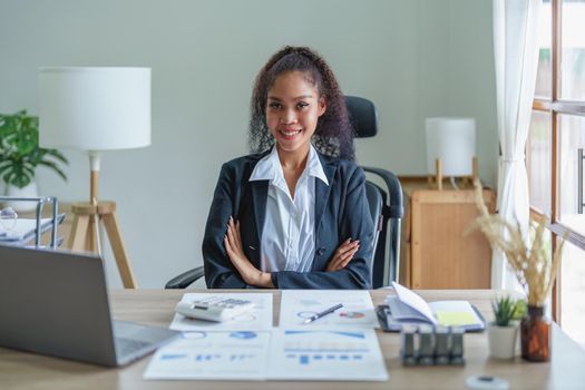 A portrait of an African Americans businesswoman showing a smile on her face as she works to increase the profits of her own business