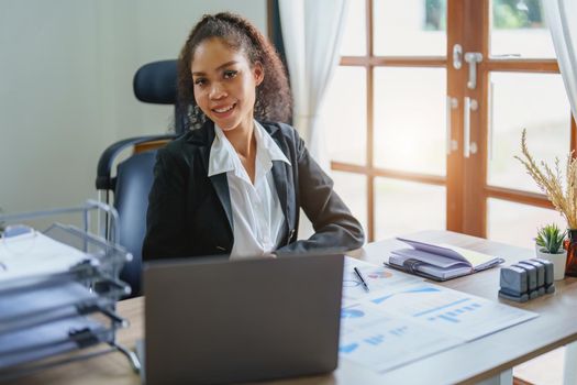 A portrait of an African Americans businesswoman showing a smile on her face as she works to increase the profits of her own business