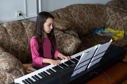 little brunette girl playing the piano with notes with flag of ukraine.