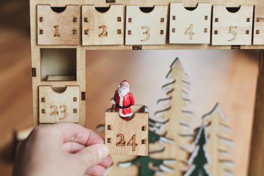 Hand opens wooden advent calendar