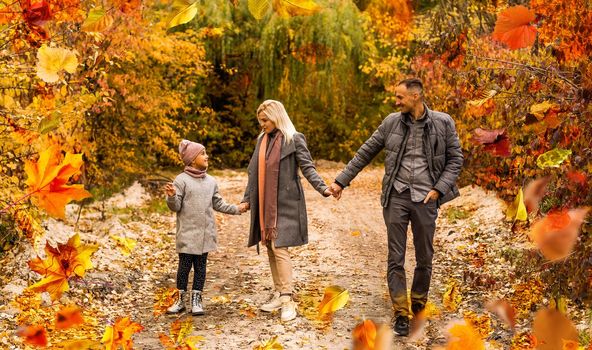 family, childhood, season and people concept - happy family playing with autumn leaves in park. High quality photo