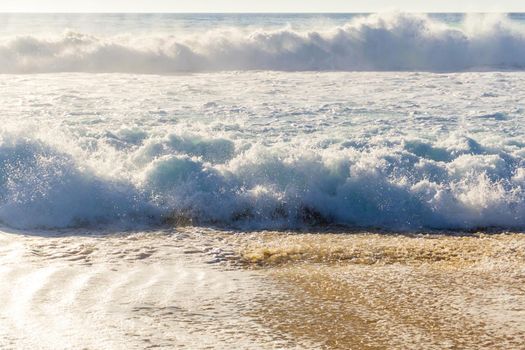 Ocean waves with white foam on a sunny day background