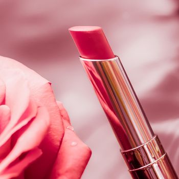 Cosmetic branding, luxe and fashion concept - Pink lipstick and rose flower on liquid background, waterproof glamour make-up and lip gloss cosmetics product for luxury beauty brand holiday design