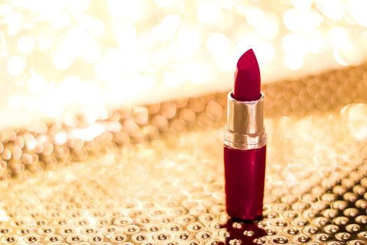 Cosmetic branding, sale and glamour concept - Dark red lipstick on golden Christmas, New Years and Valentines Day holiday glitter background, make-up and cosmetics product for luxury beauty brand