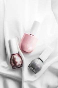 Cosmetic branding, salon and glamour concept - Nail polish bottles on silk background, french manicure products and nailpolish make-up cosmetics for luxury beauty brand and holiday flatlay art design