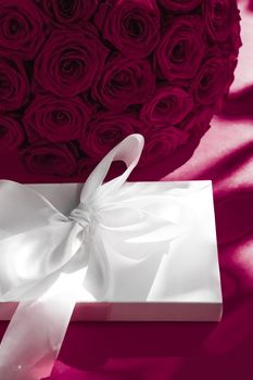 Happy holidays, luxe shopping and love gifts concept - Luxury holiday silk gift box and bouquet of roses on wine background, romantic surprise and flowers as birthday or Valentines Day present