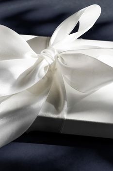 Anniversary celebration, shop sale promotion and luxe surprise concept - Luxury holiday white gift box with silk ribbon and bow on black background, luxe wedding or birthday present