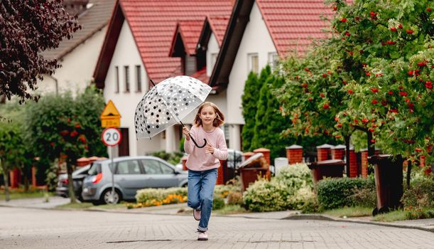 Preteen girl running outdoors and smiling. Cute pretty child kid having fun at street