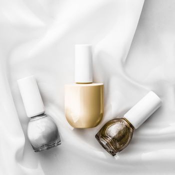 Cosmetic branding, salon and glamour concept - Nail polish bottles on silk background, french manicure products and nailpolish make-up cosmetics for luxury beauty brand and holiday flatlay art design