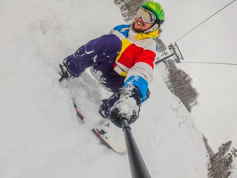 Skier skiing downhill during cloudy day in high mountains.