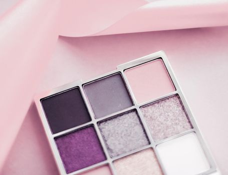 Cosmetic branding, mua and girly concept - Eyeshadow palette and make-up brush on blush pink background, eye shadows cosmetics product as luxury beauty brand promotion and holiday fashion blog design