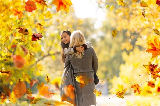 happy family: mother and child little daughter play cuddling on autumn walk in nature outdoors. High quality photo