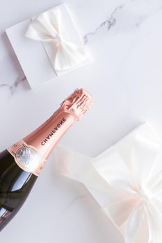 Celebration, drink and branding concept - Champagne bottle and gift box on marble, New Years, Christmas, Valentines Day or wedding holiday present and luxury product packaging for beverage brand