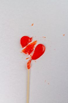 Vertical shot of broken heart shaped lollipop. Unrequited love concept.