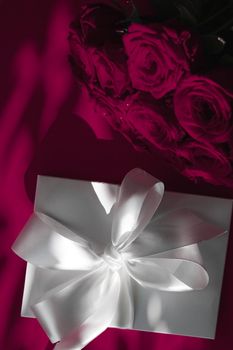 Happy holidays, luxe shopping and love gifts concept - Luxury holiday silk gift box and bouquet of roses on wine background, romantic surprise and flowers as birthday or Valentines Day present