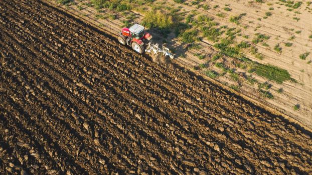 Aerial view with drone of tractor plowing the land in the countryside.