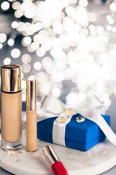 Cosmetic branding, Christmas glitter and girly blog concept - Holiday make-up foundation base, concealer and blue gift box, luxury cosmetics present and blank label products for beauty brand design