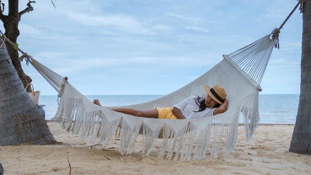 women sleeping in a hammock on a beach in Thailand, Asian women taking a nap in the afternoon.