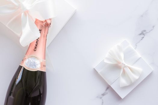 Celebration, drink and branding concept - Champagne bottle and gift box on marble, New Years, Christmas, Valentines Day or wedding holiday present and luxury product packaging for beverage brand