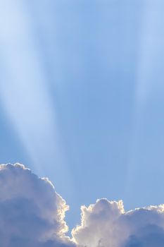 Background from blue sky with sun rays across clouds. High quality photo