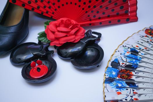 objects used in flamenco fan, castanets, high heel shoes and earrings on a white background