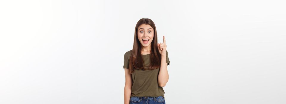 Portrait happy and surprised young lady standing isolated over grey background. Looking camera pointing