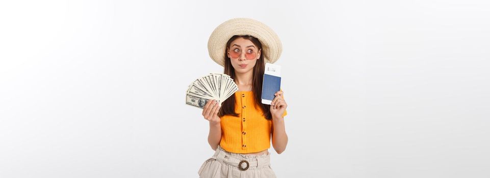 Portrait of cheerful, happy, laughing girl with hat on head, having money fan and passport with tickets in hands, isolated on white background.