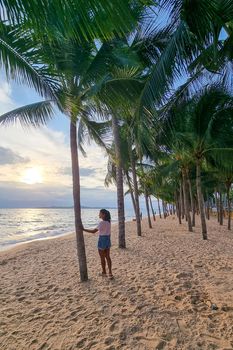 Dongtan Beach Pattaya Jomtien Thailand, palm trees on the beach during sunset. women watching sunset on beach