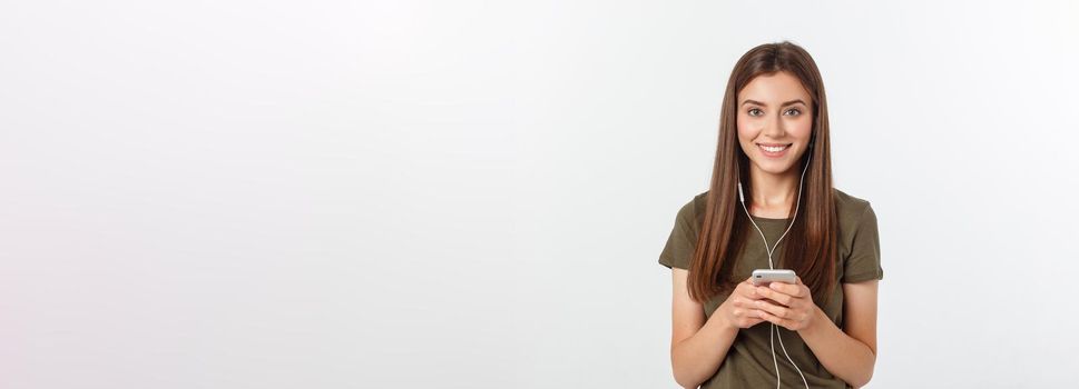 Portrait of a cheerful cute woman listening music in headphones and dancing isolated on a white background