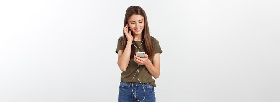 Portrait of a cheerful cute woman listening music in headphones and dancing isolated on a white background