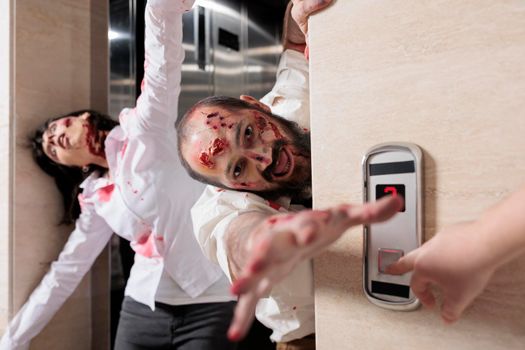 Portrait of man zombie attacking office, escaping elevator and looking dangerous with bloody scars. Eerie aggressive monsters being terrifying and chasing after people, brain eating walkers.