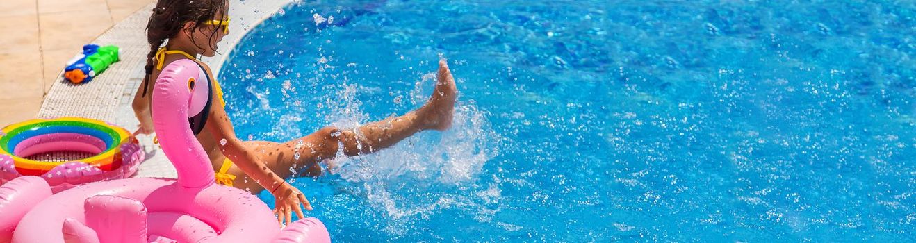 Child Splashes water in the pool. Selective focus. Kid.