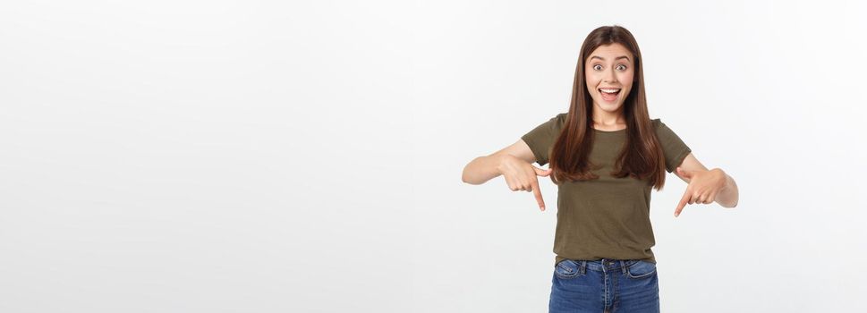 Portrait happy and surprised young lady standing isolated over grey background. Looking camera pointing