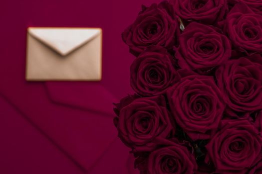 Holidays gift, floral present and happy relationship concept - Love letter and flowers delivery on Valentines Day, luxury bouquet of roses and card on maroon background for romantic holiday design