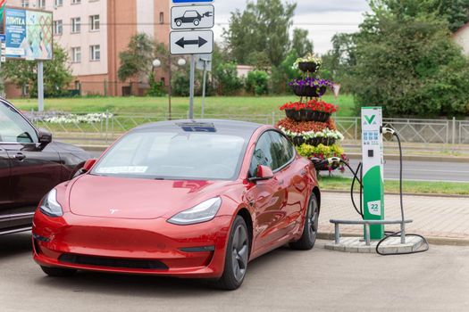 Grodno, Belarus - September 09, 2022: Tesla Model Y on 22W charging spot on Gorkogo st. - Car sharing commuter charging station. Charging technology industry transport which are the futuristic of the Automobile.