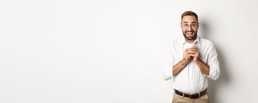 Man drinking coffee and looking excited, enjoying drink, standing over white background.