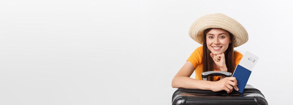 Travel concept. Studio portrait of pretty young woman holding passport and luggage. Isolated on white.