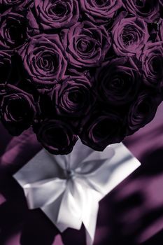 Happy holidays, luxe shopping and love gifts concept - Luxury holiday silk gift box and bouquet of roses on purple background, romantic surprise and flowers as birthday or Valentines Day present