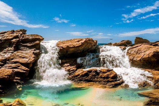 Water tumbles over rocks and into an ocean rockpool