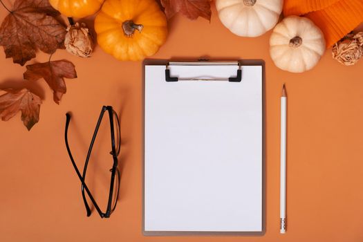 Blank notebook for text next to pumpkins and autumn leaves. Autumn theme mockup.