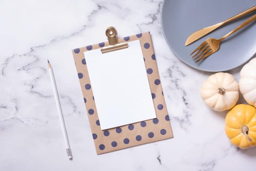 Autumn flat lay with blank tablet and decorative pumpkins on marble background top view.