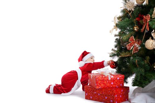 baby in santa claus costume decorate fir tree