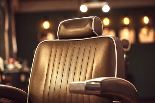 Close up brown leather chair in barbershop. Loft style