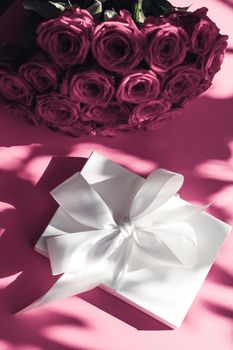 Happy holidays, luxe shopping and love gifts concept - Luxury holiday silk gift box and bouquet of roses on pink background, romantic surprise and flowers as birthday or Valentines Day present